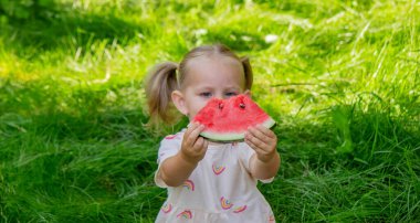 Mutlu çocuk karpuz yiyor. Yaz.