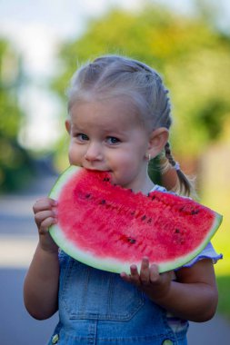 Mutlu çocuk karpuz yiyor. Yaz.