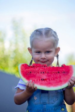 Mutlu çocuk karpuz yiyor. Yaz.