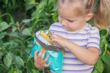 Doğal bir geçmişi olan bir paket cipsi olan kız. Sağlıksız yemek..