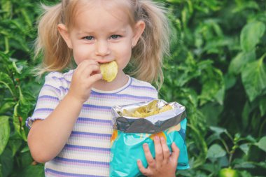 Doğal bir geçmişi olan bir paket cipsi olan kız. Sağlıksız yemek..