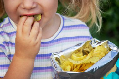 Doğal bir geçmişi olan bir paket cipsi olan kız. Sağlıksız yemek..