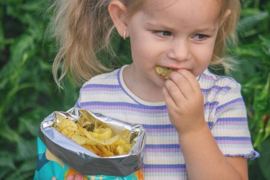 Doğal bir geçmişi olan bir paket cipsi olan kız. Sağlıksız yemek..