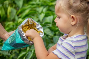 Doğal bir geçmişi olan bir paket cipsi olan kız. Sağlıksız yemek..