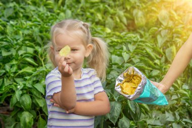 Doğal bir geçmişi olan bir paket cipsi olan kız. Sağlıksız yemek..