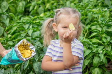 Doğal bir geçmişi olan bir paket cipsi olan kız. Sağlıksız yemek..