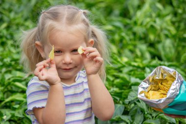Doğal bir geçmişi olan bir paket cipsi olan kız. Sağlıksız yemek..