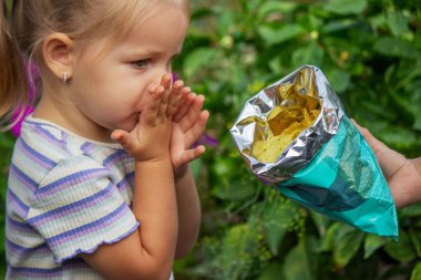 Doğal bir geçmişi olan bir paket cipsi olan kız. Sağlıksız yemek..