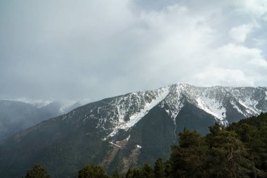 Dostum, Andorra. Nisan 2022. Andorra Pireneleri 'nde fırtınalı bir gün. Mevsimin son karı ilkbaharın başlarında.