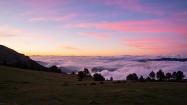 Coll de Pal, Bergueda, Girona, İspanya. Ağustos 2022. Dağların üzerinde nefes kesen güneşin doğuşunu izle. Bulut denizi kıvrılır ve akar. Zirvelere çarpıcı bir sıçrama etkisi yaratır..