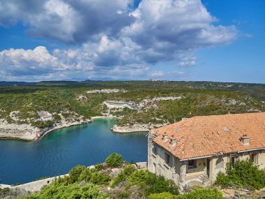 Bonifacio şehri, Fransa 'nın Korsika adasındaki Akdeniz' in turkuaz suyuyla çevrili beyaz bir uçurumun üzerinde uzanıyor.