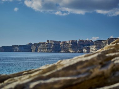 Bonifacio şehri, Fransa 'nın Korsika adasındaki Akdeniz' in turkuaz suyuyla çevrili beyaz bir uçurumun üzerinde uzanıyor.