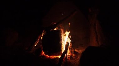 Patagonya 'da parlayan kömür ve yanan odunlarla açık bir kamp ateşinin yavaş çekimleri