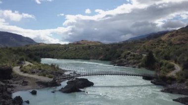 Carretera Austral, Patagonya, Şili, Güney Amerika boyunca akarsu akıntısı ve turkuaz nehri ile Rio Baker üzerinde turuncu asma köprüsü.