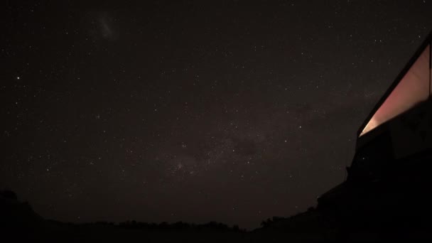 在阿根廷的巴塔哥尼亚 在南半球漆黑的夜空中 在四轮驱动的越野车生命车旁边 一颗流星在漫漫银河中飞驰而过 — 图库视频影像