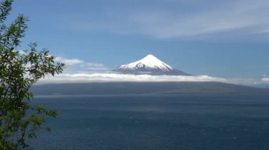 Osorno volcano in Patagonia chile on a clear day with blue sky and a few clouds.