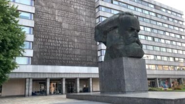 Chemnitz, Almanya - 09 08 2021: Karl Marx anıtı, taşa kazınmış büyük harflerle komünist tezinin metnini gösteren bir binanın önünde.