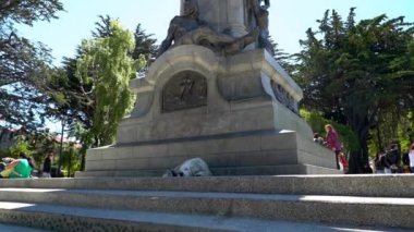 Punta Arenas, Chile - 11 17 2018: Magellan monument with a statue of a native patagonian man in the city center of Punta Arenas in Patagonia on a windy day, documenting colonizing of South America.