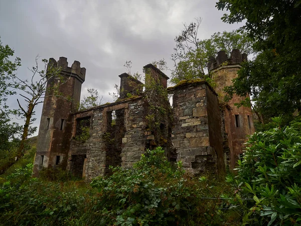 old historic ruin in the landscape of ireland on a cloudy and overcast day.