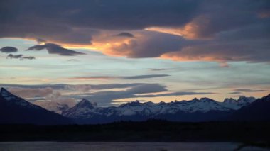 El Calafate, Patagonya, Arjantin 'deki perito moreno buzuluna yakın turuncu bulutlarla dramatik günbatımı.