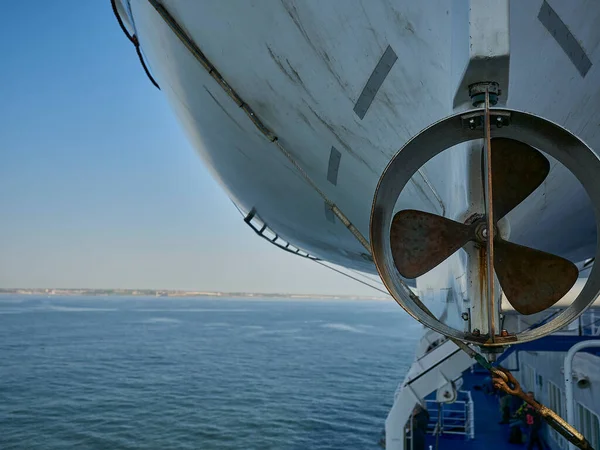 青い空の晴れた日に外洋を航行する船舶の側面に掛かる救命艇のプロペラの詳細 — ストック写真