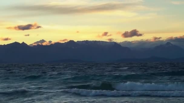 背景にサン カルロス バリローチェとパタゴニアの風の強い日の日没時にナウエル ハピ湖に上陸粉砕波 — ストック動画