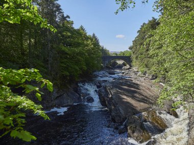 Invermoriston açık mavi gökyüzü ile güneşli bir günde İskoçya 'daki Loch Ness yakınlarına düşer..