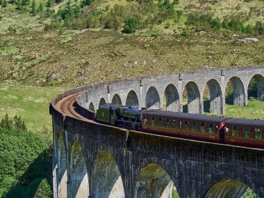 Glenfinnan, İskoçya - 05: 29: 2018: İskoçya dağlarındaki Glenfinnan viyadük geçidinden geçen ikonik jakobit buharlı tren.