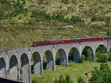 Glenfinnan, İskoçya - 05: 29: 2018: İskoçya dağlarındaki Glenfinnan viyadük geçidinden geçen ikonik jakobit buharlı tren.