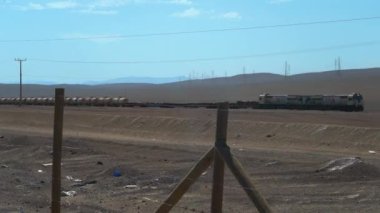 Uzun tren çorak ve tozlu Atacama çölünden geçiyor Antofagasta 'ya yakın Pan Amerikan otoyolu boyunca..