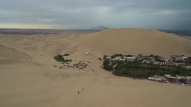 Huacachina, Ica kentine yakın bir çöl vahası ve küçük bir köydür ve kum arabası sürmek veya kum kaykayı gibi eğlence amaçlı popüler bir seyahat merkezidir..