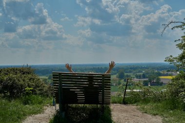 Almanya 'da Tecklenburg yakınlarındaki Teuroschleifen yürüyüş parkurunda yürüyüş yaparken bir bankta oturan tanınmamış genç bayan yürüyüşçü..