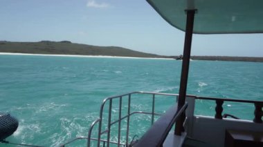 Pasifik Okyanusu 'nun turkuaz deniz suyu boyunca Galapagos adalarının beyaz kumlu sahillerinde küçük motorlu yat geziniyor..