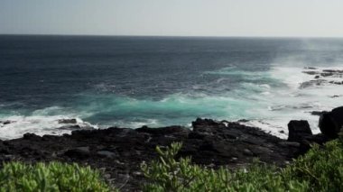 Pasifik Okyanusu 'nun deniz suyu bir hava deliğinden geçiriliyor ve Galapagos adalarındaki lav kayaları plajına tuzlu su püskürtüyor..