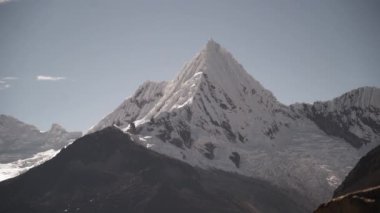 Huascaran, Peru 'daki Cordillera blanca' nın yüksek And Dağları 'ndaki laguna paron lagünündeki piramit şekilli buzulun karla kaplı tepeleri parlak güneşli bir günde karla kaplıydı..