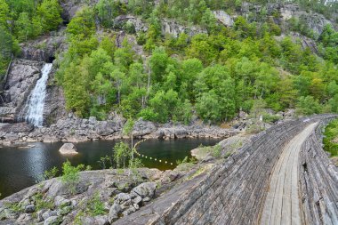 Norveç 'in güneyinde Vennesla yakınlarındaki Tommerrenna' nın tarihi restore edilmiş ahşap sal kanalı ya da kereste kaydırağı yürüyüşçüleri için popüler bir yerdir.