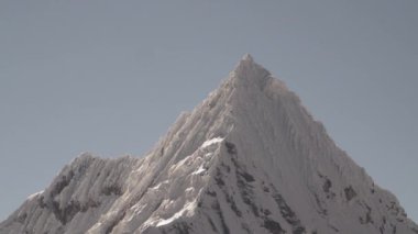 Huascaran, Peru 'daki Cordillera blanca' nın yüksek And Dağları 'ndaki laguna paron lagünündeki piramit şekilli buzulun karla kaplı tepeleri parlak güneşli bir günde karla kaplıydı..