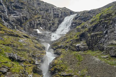 Norveç 'in dağlarındaki Trollstigen manzaralı yolda bir dağ manzarasında şelale.