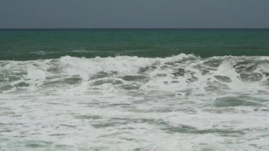 Dalgalar, Kolombiya 'daki Sierra Nevada de Santa Marta' daki Atlantik Okyanusu 'nun tropikal kıyısı boyunca Tayrona Ulusal Parkı yakınlarındaki beyaz kumsala çarpıyor..