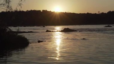 Güney Brezilya 'da uzak bir nehrin akıntıları üzerinde romantik bir gün batımı.