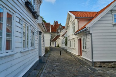 Stavanger, Norveç - 05: 29: 2022: Rogaland, Norveç 'te Gamle Stavanger' da güzel geleneksel beyaz ahşap evleri olan tarihi cadde, güneşli bir gün.