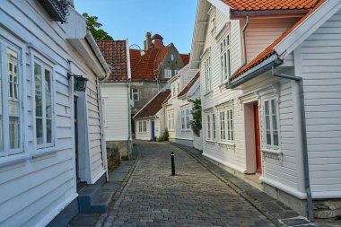 Stavanger, Norveç - 05: 29: 2022: Rogaland, Norveç 'te Gamle Stavanger' da güzel geleneksel beyaz ahşap evleri olan tarihi cadde, güneşli bir gün.