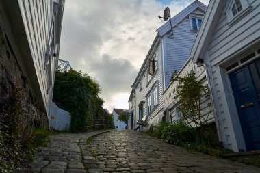 Stavanger, Norveç - 05: 29: 2022: Rogaland, Norveç 'te Gamle Stavanger' da güzel geleneksel beyaz ahşap evleri olan tarihi cadde, güneşli bir gün.