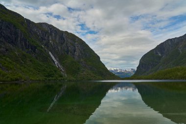 Güzel Bondhus Vatnet dağ gölü Norveç 'in dağlık kesimlerinde mavi bir buzulun eteklerinde, doğa severler ve doğa yürüyüşçüleri için popüler bir seyahat merkezi..