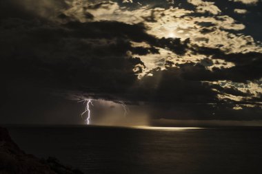 Akdeniz 'in üzerinde gece vakti yıldırımlarla aydınlatılmış kara bulutlarla muhteşem bir fırtına var..