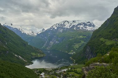 Güzel Geiranger Fjord, yolcu gemileri için iyi bilinen ve popüler bir seyahat merkezidir ve Norveç 'in derin vadileri ve karla kaplı sıradağları ile muhteşem manzaralar sunar..