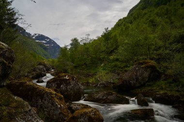 Norveç 'in dağlık bölgelerindeki güzel Bondhus Vatnet Gölü' ne doğru şelale boyunca, doğa severler ve yürüyüşçüler için popüler bir seyahat yeri..