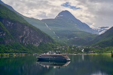 Güzel Geiranger Fjord, yolcu gemileri için iyi bilinen ve popüler bir seyahat merkezidir ve Norveç 'in derin vadileri ve karla kaplı sıradağları ile muhteşem manzaralar sunar..