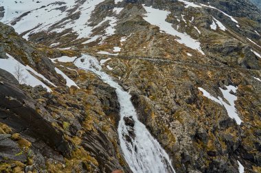 Norveç 'in dağlarındaki Trollstigen manzaralı yolda bir dağ manzarasında şelale.