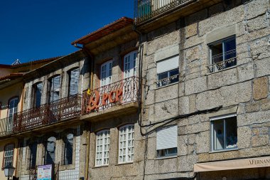 Guimaraes, Portekiz - 09: 30: 2022: Güneşli bir günde geleneksel Portekiz tarzında tarihi mimarisi olan Guimaraes şehir merkezindeki dar sokaklar.